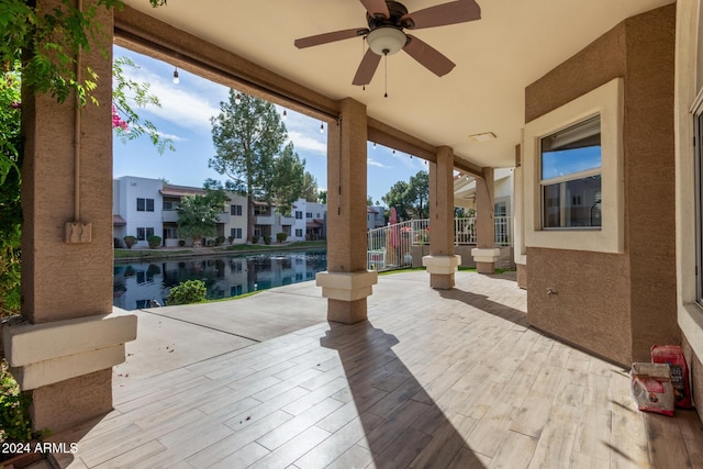 view of patio with ceiling fan and a water view