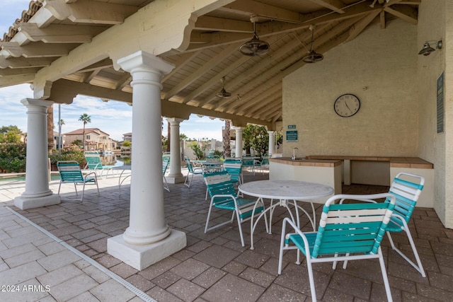 view of patio featuring ceiling fan and a community pool