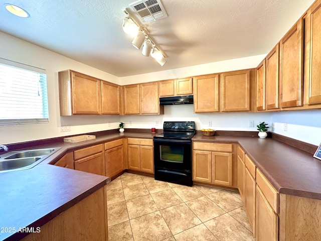 1649 W Wilson Ave, Coolidge, AZ 85128 - kitchen with black / electric stove, under cabinet range hood, dark countertops, rail lighting, and light tile patterned flooring