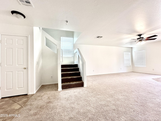 1649 W Wilson Ave, Coolidge, AZ 85128 - unfurnished living room featuring ceiling fan, carpet, stairway, and a textured ceiling