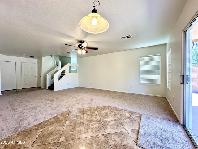 1649 W Wilson Ave, Coolidge, AZ 85128 - unfurnished living room featuring carpet flooring, tile patterned flooring, ceiling fan, a textured ceiling, and stairs