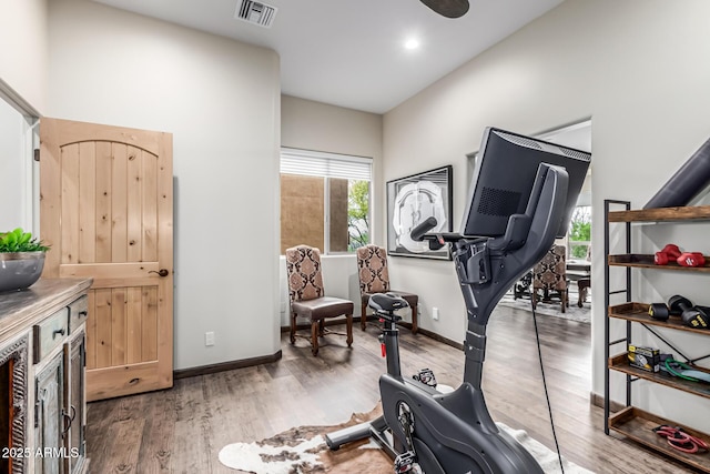 exercise area with wood finished floors and baseboards