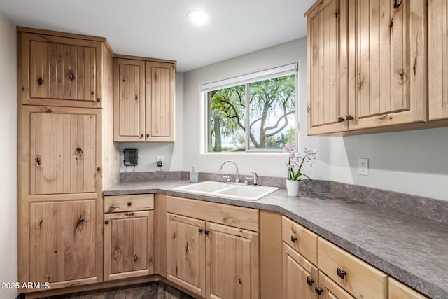 kitchen with a sink, light brown cabinets, dark countertops, recessed lighting, and dark wood-style floors