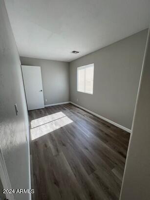 unfurnished bedroom featuring baseboards and wood finished floors