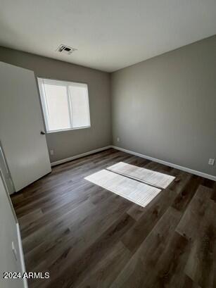 interior space with wood finished floors, visible vents, and baseboards