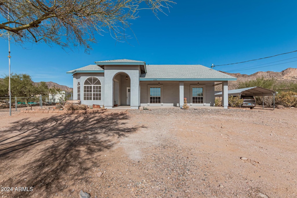 view of front of property with a carport, a mountain view, and covered porch