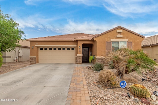 view of front of home with driveway, stone siding, stucco siding, a tiled roof, and a garage