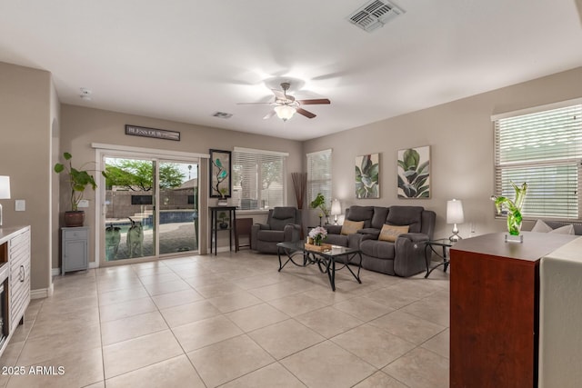 living area with plenty of natural light, visible vents, and ceiling fan