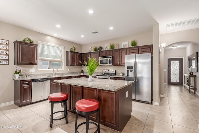 kitchen featuring visible vents, arched walkways, a sink, and stainless steel appliances