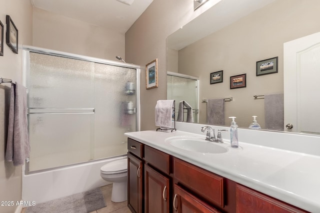 bathroom featuring tile patterned floors, bath / shower combo with glass door, toilet, and vanity