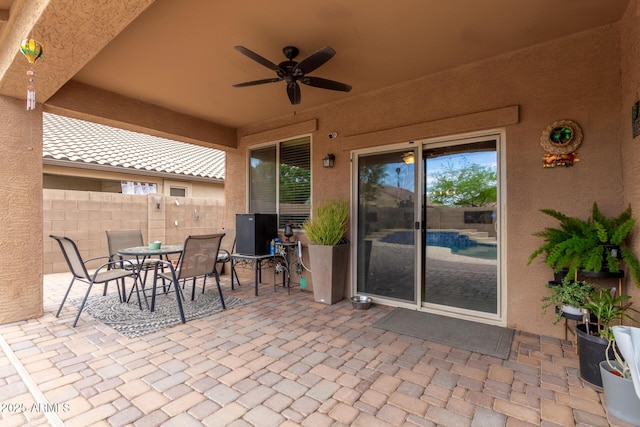 view of patio / terrace with outdoor dining area, fence, and a ceiling fan