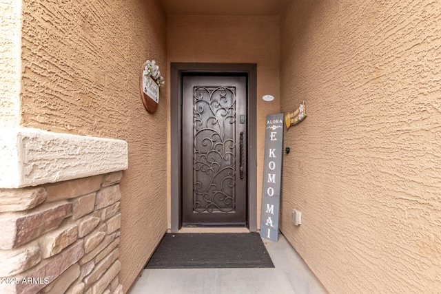 view of exterior entry featuring elevator and stucco siding