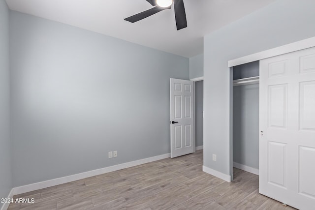 unfurnished bedroom with ceiling fan, light hardwood / wood-style floors, and a closet