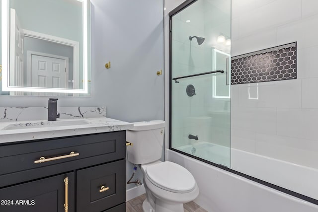 full bathroom featuring vanity, enclosed tub / shower combo, and toilet