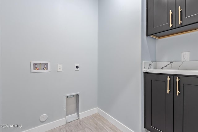 washroom featuring gas dryer hookup, cabinets, hookup for a washing machine, electric dryer hookup, and light wood-type flooring