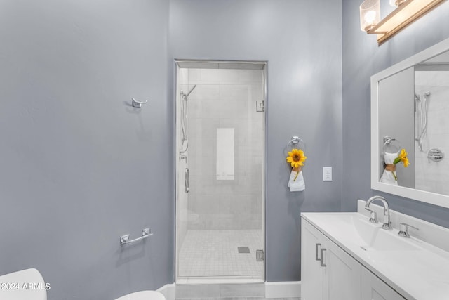 bathroom featuring vanity, toilet, and a shower with shower door