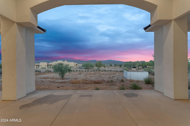 patio terrace at dusk featuring a mountain view