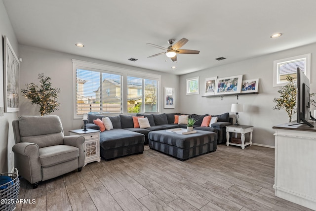 living room with light hardwood / wood-style floors and ceiling fan