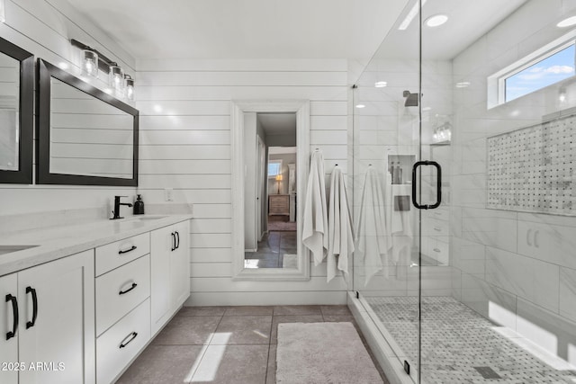 bathroom with walk in shower, vanity, and tile patterned flooring