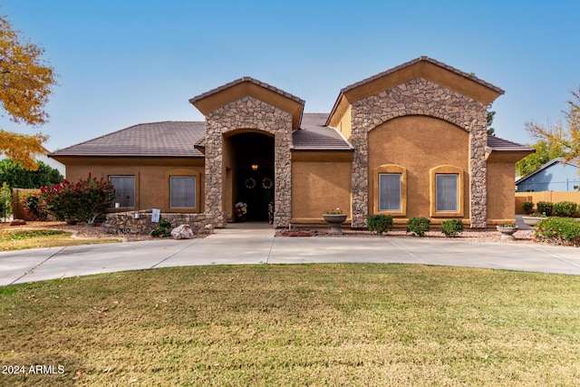 mediterranean / spanish home featuring a front lawn