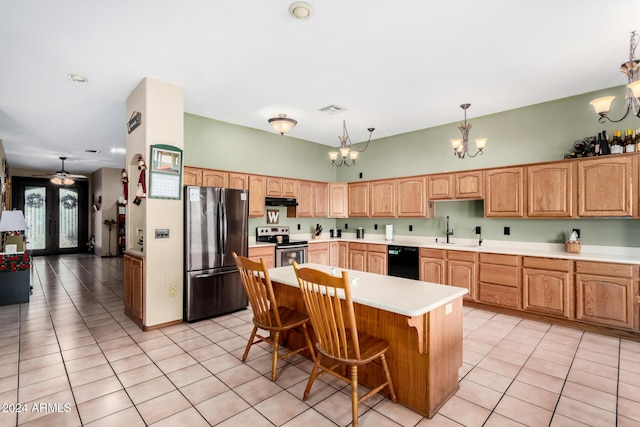 kitchen featuring pendant lighting, appliances with stainless steel finishes, a center island, an inviting chandelier, and light tile patterned flooring