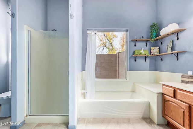 full bathroom with toilet, separate shower and tub, and vanity