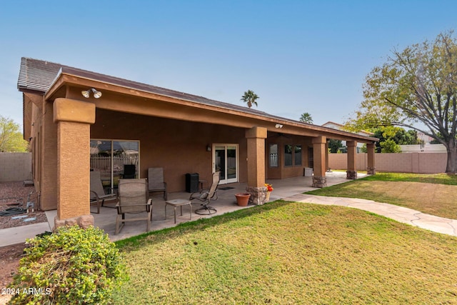 rear view of house featuring a yard and a patio