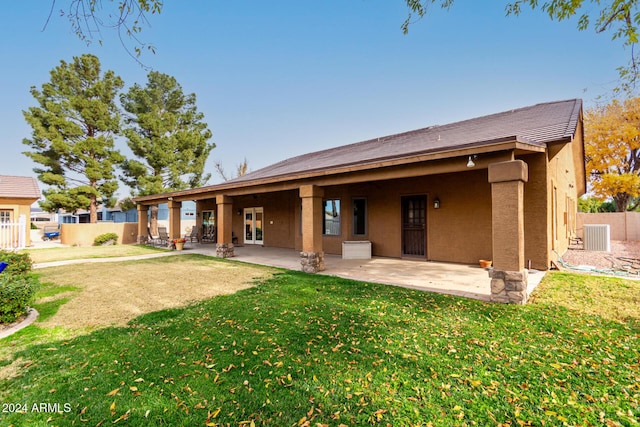 back of house with cooling unit, a lawn, and a patio