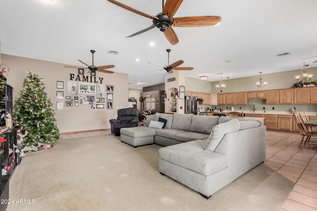 living room featuring light tile patterned floors, ceiling fan with notable chandelier, and sink