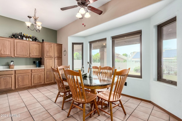 tiled dining space featuring ceiling fan with notable chandelier