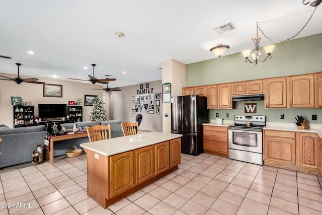 kitchen featuring ceiling fan with notable chandelier, appliances with stainless steel finishes, a kitchen island, and light tile patterned flooring