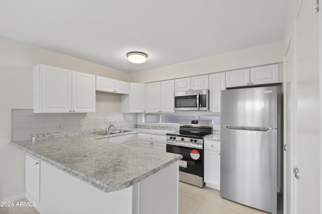 kitchen featuring white cabinetry, sink, stainless steel appliances, kitchen peninsula, and decorative backsplash