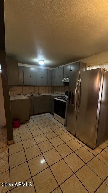 3530 W Portland St, Phoenix, AZ 85009 - kitchen with stainless steel refrigerator with ice dispenser, gas range gas stove, a textured ceiling, decorative backsplash, and light tile patterned floors