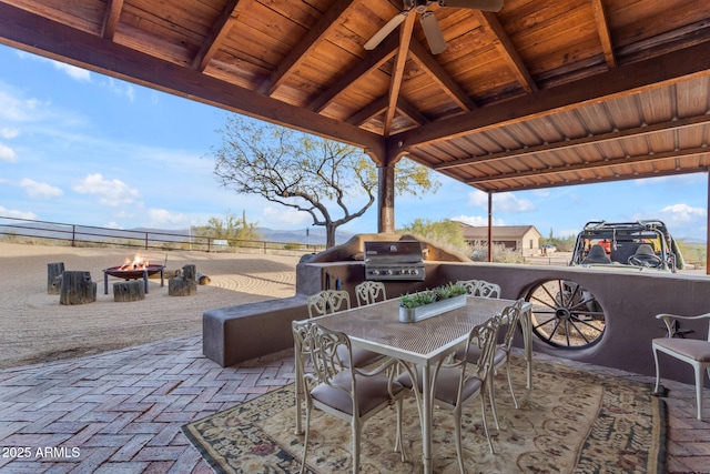 view of patio / terrace featuring ceiling fan, an outdoor fire pit, grilling area, and exterior kitchen