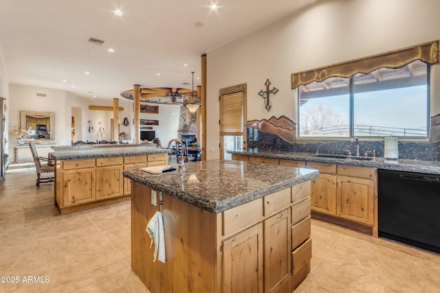 kitchen featuring ceiling fan, sink, dishwasher, and an island with sink