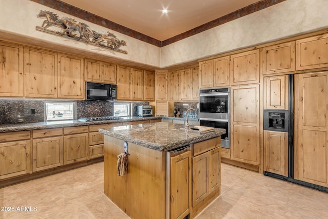 kitchen featuring sink, black appliances, a center island with sink, decorative backsplash, and dark stone counters