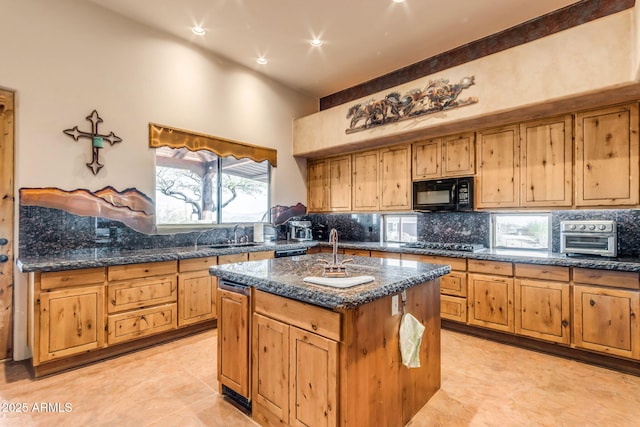 kitchen with a towering ceiling, tasteful backsplash, dark stone countertops, a kitchen island with sink, and black appliances