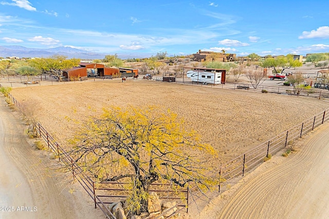 view of yard featuring a mountain view, a rural view, and an outdoor structure