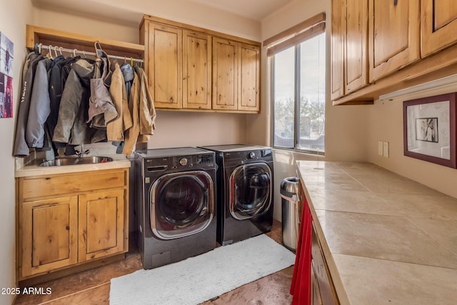 laundry room with cabinets, separate washer and dryer, and sink