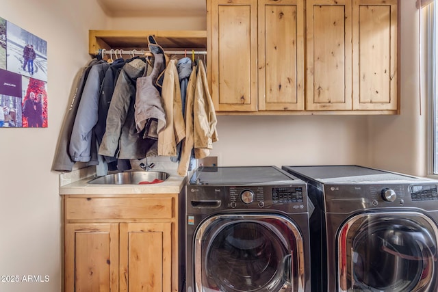 clothes washing area with sink, cabinets, and washing machine and clothes dryer