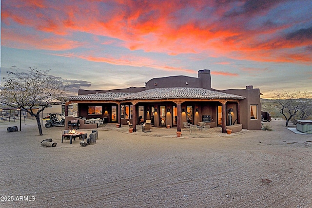 back house at dusk with a patio area