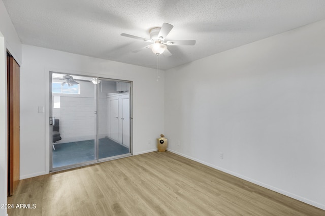 unfurnished bedroom featuring light wood finished floors, a closet, a ceiling fan, a textured ceiling, and baseboards