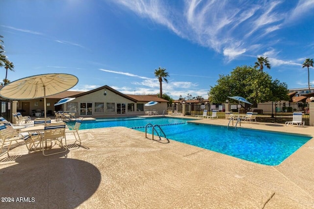 community pool featuring fence and a patio