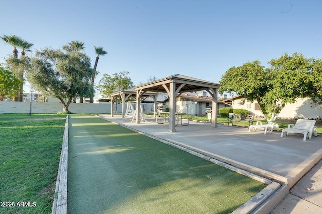 view of community with fence, a gazebo, and a lawn