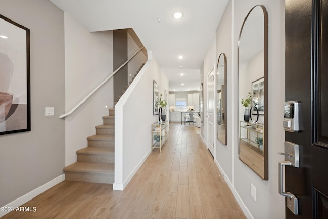 foyer with recessed lighting, stairway, baseboards, and light wood-style flooring