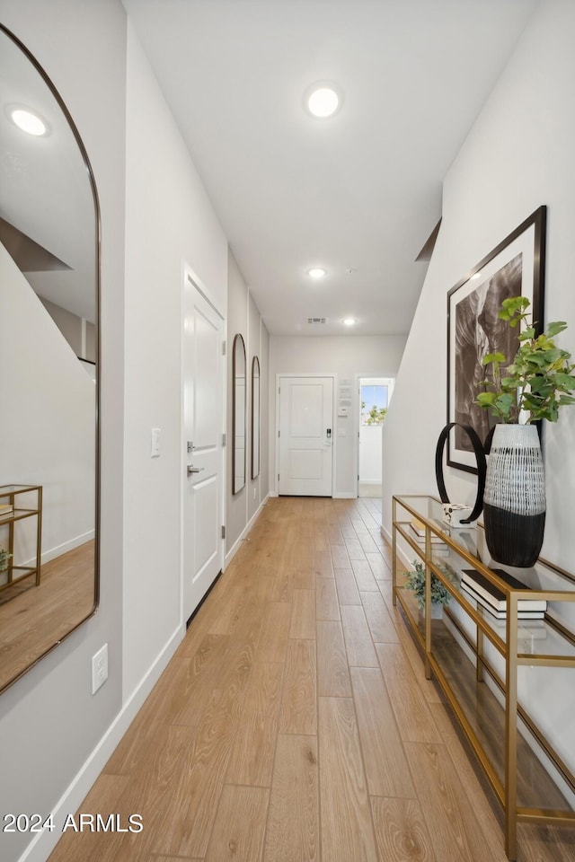 hall featuring recessed lighting, baseboards, and light wood-type flooring