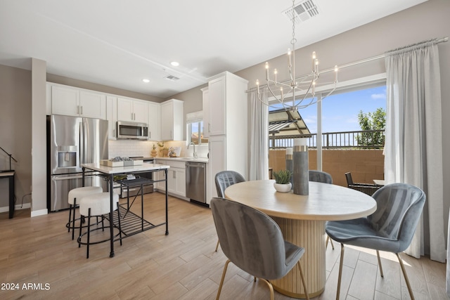 dining area featuring recessed lighting, visible vents, light wood-style flooring, and a chandelier