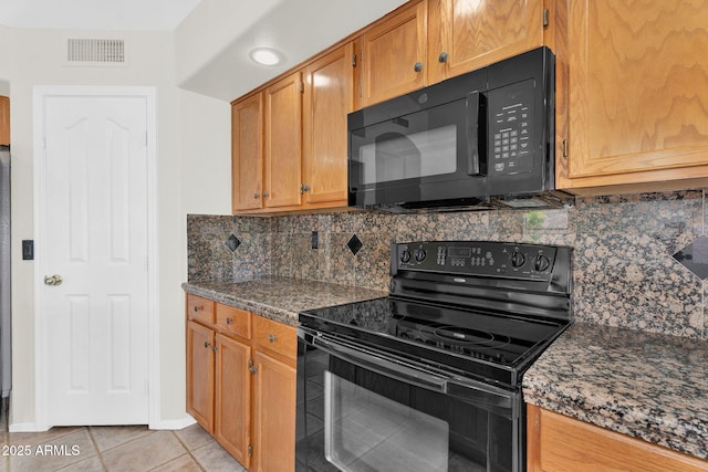 kitchen featuring black appliances, tasteful backsplash, light tile patterned floors, baseboards, and brown cabinetry
