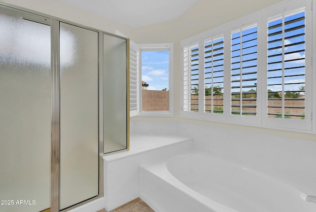 bathroom featuring a shower stall and a bath