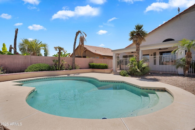 view of swimming pool with ceiling fan and a fenced backyard
